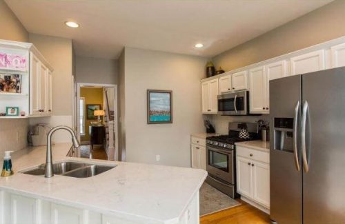 Countertop: Corian Quartz London Sky Backsplash: Full height Corian Cameo White in a subway tile design